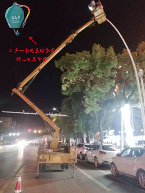 夜晚工人站在升降平臺車上進行路燈更換